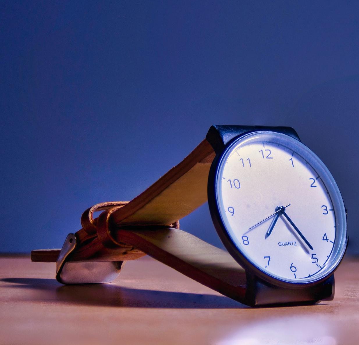 blue and white analog alarm clock at 10 10